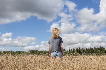 young girl standing in a wheat field