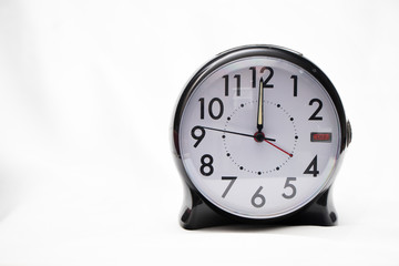 Alarm clock showing twelve o'clock against white background
