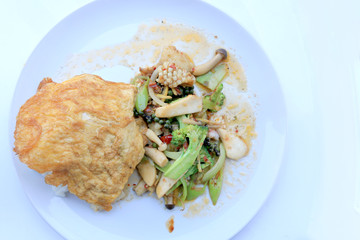 Stir fried Spicy Seafood with black pepper and thai style omelette with rice on white dish,  Thai spicy herb food / Image select focus