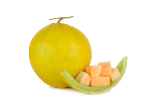 whole and portion cut fresh yellow melon with stem on white back