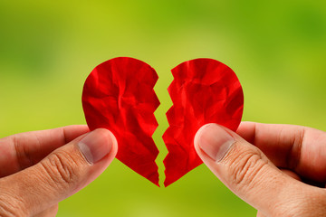 hand holding red paper broken heart for divorce or reconcile