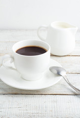 Black coffee and milk jug in a white bowl