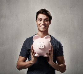Smiling man with piggy bank.
