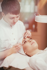 Professional stylist making eyelash extension for women