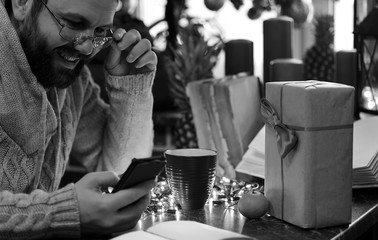monochrome beard man writing christmas gifts on a table