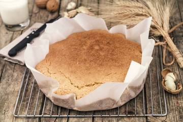 Yogurt cake and coconut. Cup of milk and knife on wooden background