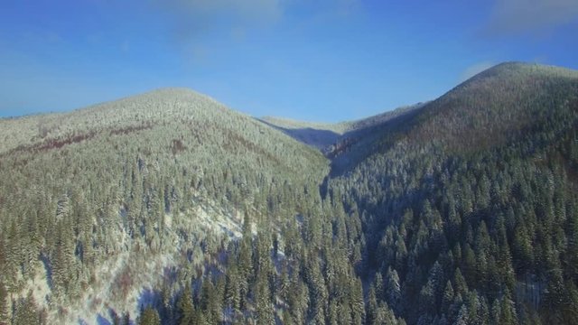 Aerial. Flying above winter mountains. Snow landscape. Movement forward. 4K