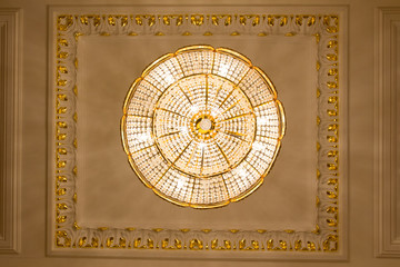Fototapeta na wymiar Crystal luxury chandelier in golden ballroom