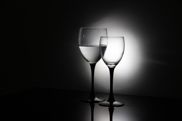 Glasses of champagne and a bottle of wine on a black background