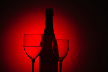 Glasses of champagne and a bottle of wine on a black background