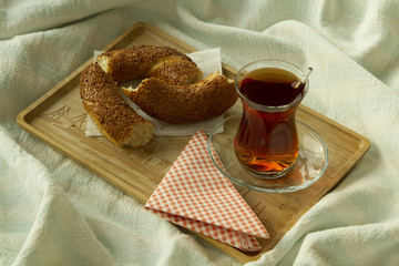 Morning turkish tea in traditional glass with bagel on the tray,