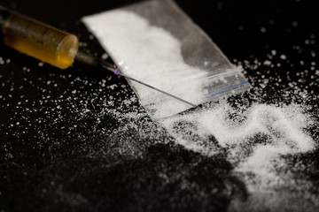 Drug syringe and cooked heroin. Cocaine in the bag, scattered. I