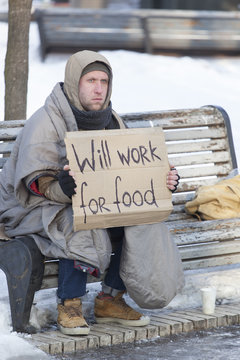 
 Young   Hungry  Homeless Man In  Winter City Park Looking For Job
