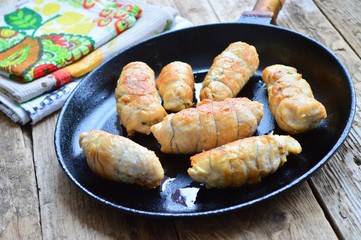 Fried chicken rolls in a frying pan