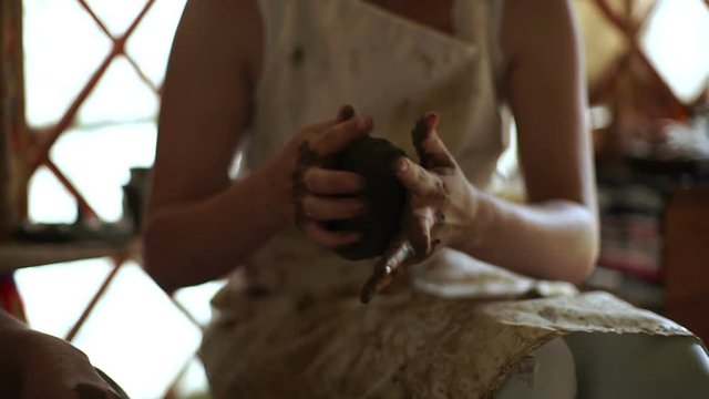 woman's hands makes a pot on pottery wheel