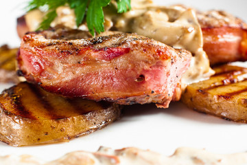 Juicy grilled steak on plate side view.. Close-up of barbecue pork chop served with potato and creamy sauce. Meat meal background. Dining, junk food, restaurant menu concept