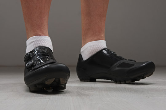 Low view of male legs in cycling boots.