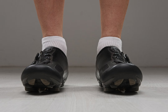 Low view of male legs in cycling boots.