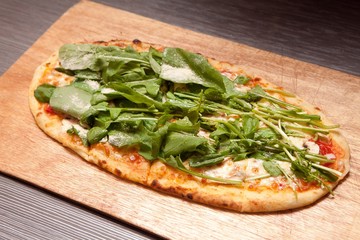 arugula  pizza on table