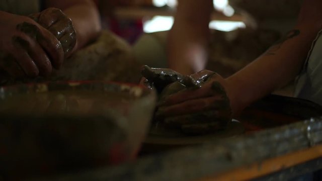 woman's hands makes a pot on pottery wheel