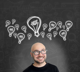 Bulb lamp icons going out of the head of a Young attractive smil