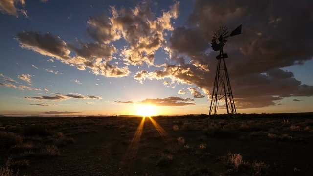 Timelapse of windmill with clouds and sunset in american desert