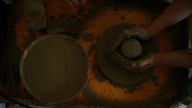 woman's hands makes a pot on pottery wheel