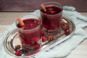 mulled wine with cherries, cinnamon and star anise in a glass on vintage silver tray