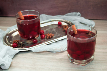 mulled wine with cherries, cinnamon and star anise in a glass on vintage silver tray