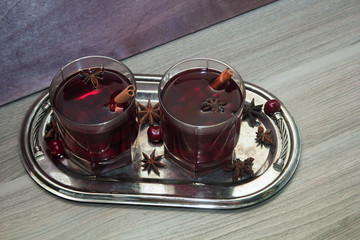 mulled wine with cherries, cinnamon and star anise in a glass on vintage silver tray