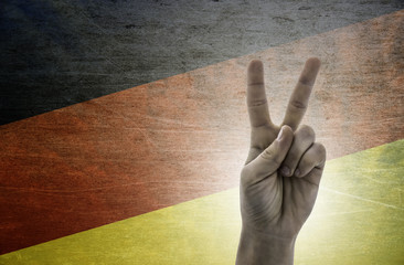 Victory symbol - two fingers against background of Germany flag