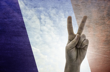 Victory symbol - two fingers against background of France flag