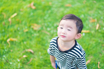 Close-up little Asian boy looking up somewhere and thinking with