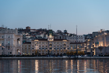 Fototapeta na wymiar Ultimi raggi di sole sul mare e sui palazzi di Trieste