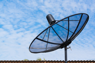 Satellite dish on the roof with blue sky.