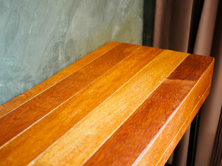 wooden table with Cement wall and brown curtain