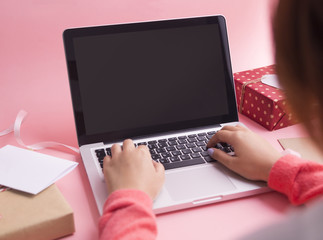 Women hand use computer on pink background.