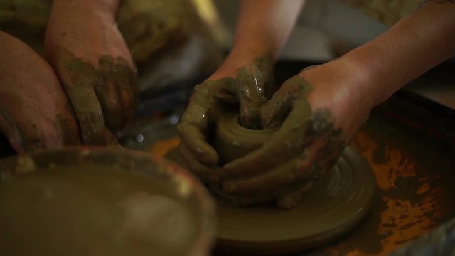 woman's hands makes a pot on pottery wheel