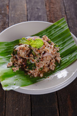 spicy minced pork salad on fresh banana leaf