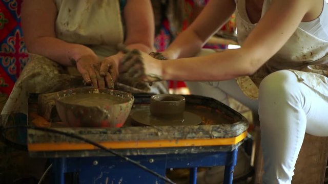 woman's hands makes a pot on pottery wheel