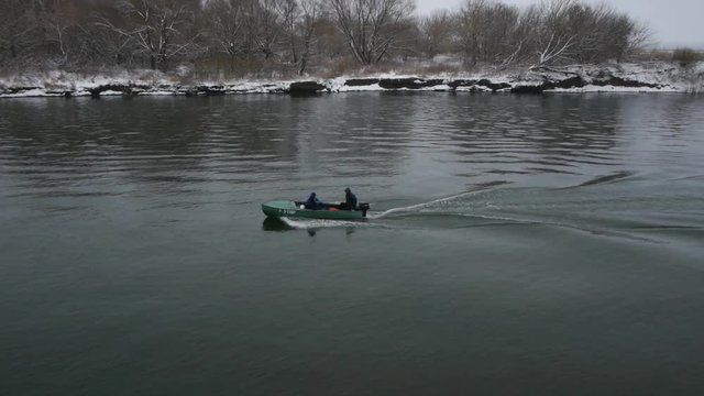 motor boat floats on the river winter. drone shot