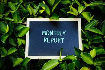 mini blackboard over the green nature written Monthly Report