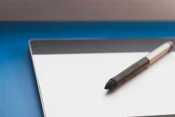The tablet on the table and a pen,