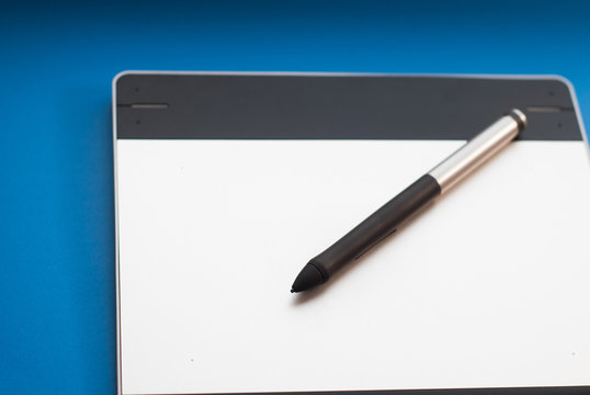 The tablet on the table and a pen,