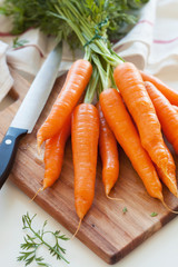 raw carrot vegetable on wooden chopping board