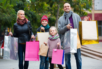 Parents with children shopping in city.