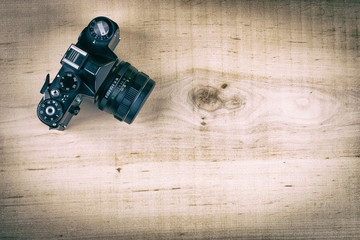 Retro SLR camera on wooden background with copy space. Vintage style.