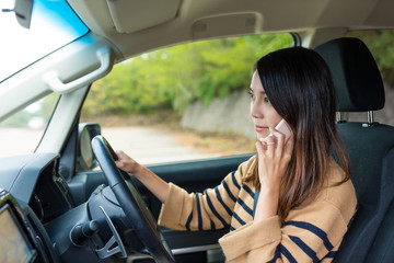 Fototapeta na wymiar Woman talk to cellphone and driving car