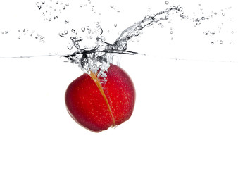 Fototapeta na wymiar red apple fruits making splash in water