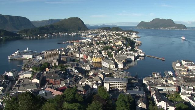Elevated view over Alesund, Norway from Aksla as a costal ferry leaves port. The island of Godoya is in the background